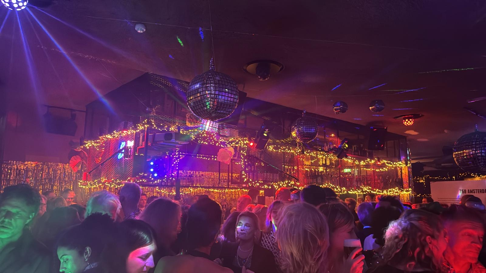 Volle dansvloer onder discoballen